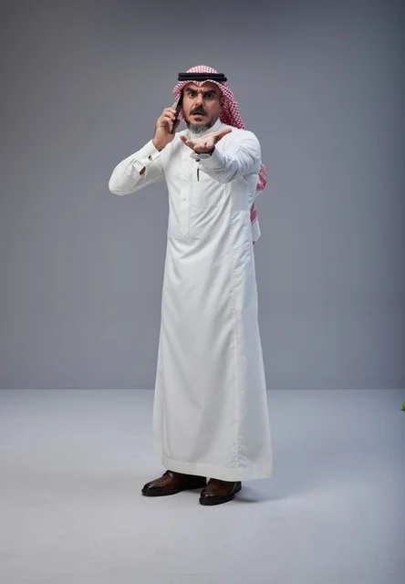 رجل سعودي يتحدث عبر الهاتف الجوال بتعبير غاضب