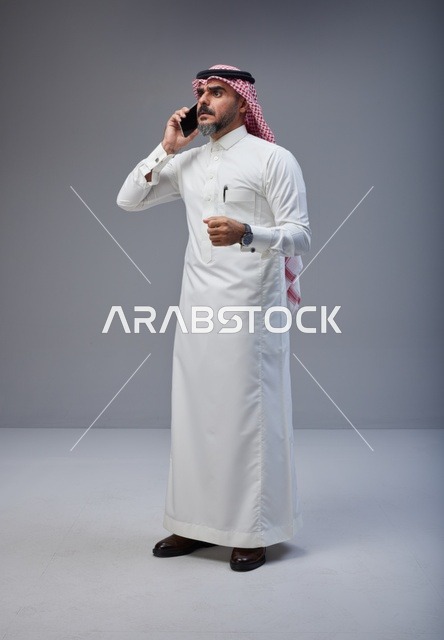 رجل سعودي بالزي التقليدي يتحدث عبر الهاتف