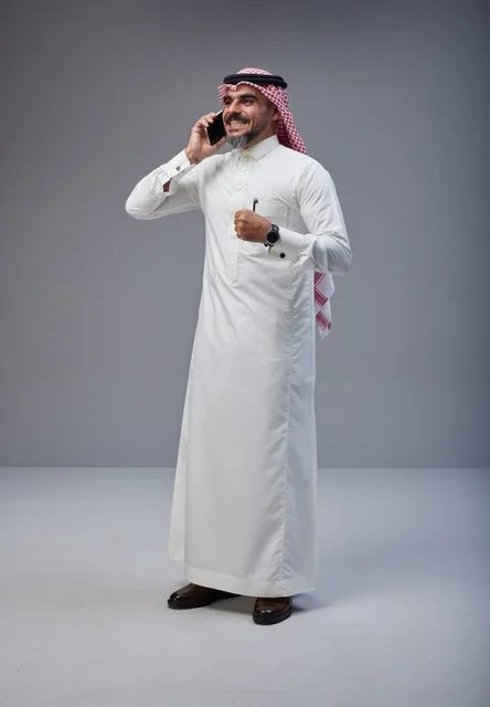 Saudi Man in Traditional Dress Talking on Smartphone