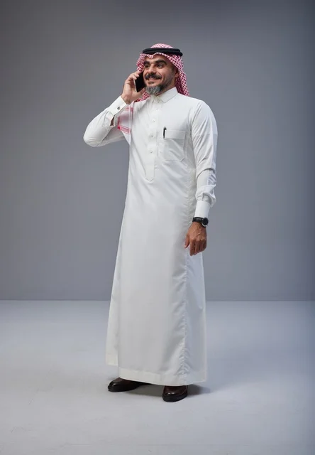 Saudi Man in Traditional Dress Talking on Smartphone