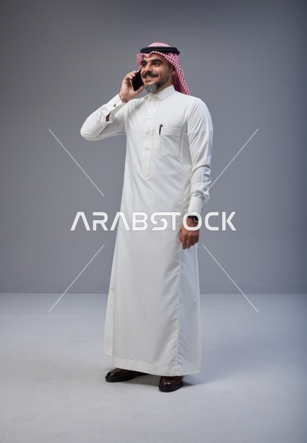 رجل سعودي بالزي التقليدي يتحدث عبر الهاتف