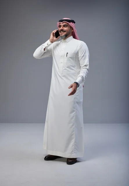 رجل سعودي بالزي التقليدي يتحدث عبر الهاتف الجوال