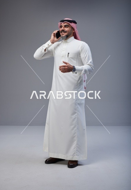 رجل سعودي بالزي التقليدي يتحدث عبر الهاتف