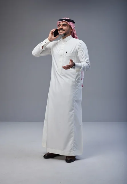 Saudi Man in Traditional Thobe Talking on Smartphone Studio