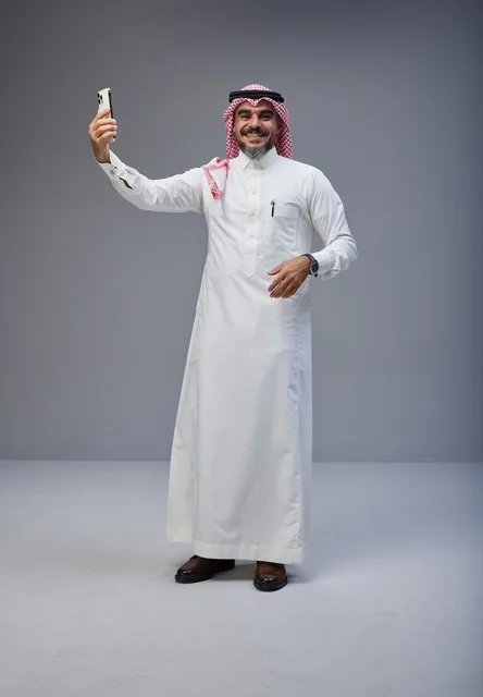 رجل سعودي بالزي التقليدي يلتقط صورة سيلفي