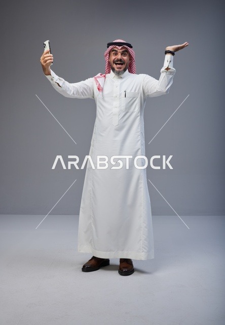 Saudi Man in Traditional Thobe Taking Excited Selfie