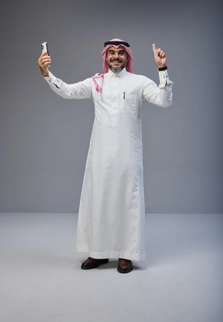 رجل سعودي بالزي التقليدي يلتقط سيلفي في الاستوديو