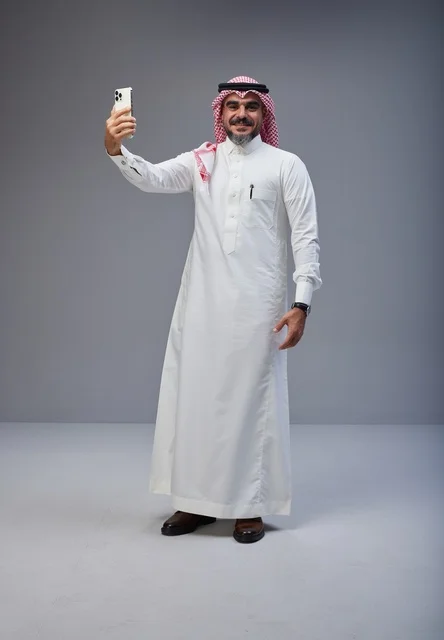 رجل سعودي بالزي التقليدي يلتقط سيلفي بالهاتف