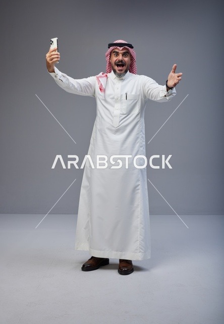 Saudi Man in Traditional Thobe Taking Excited Selfie