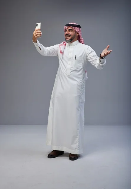 رجل سعودي بالزي التقليدي يلتقط صورة سيلفي