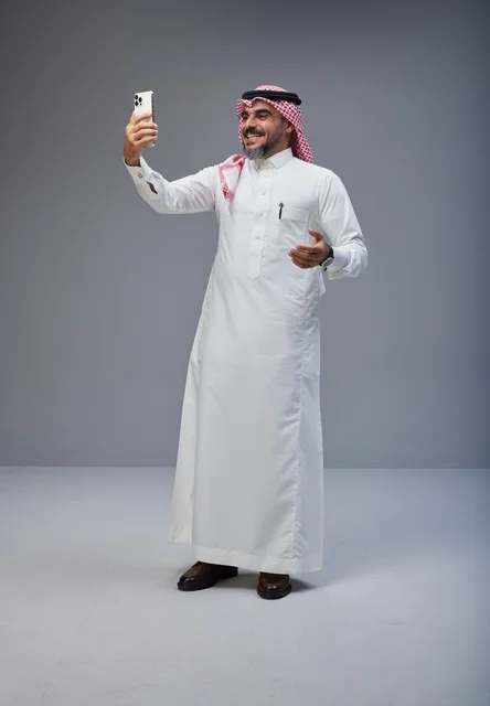رجل سعودي بالزي التقليدي يلتقط سيلفي في الاستوديو