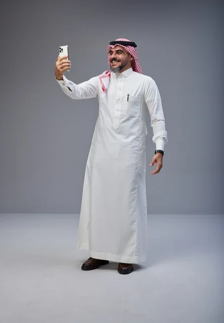 رجل سعودي بالزي التقليدي يلتقط صورة سيلفي