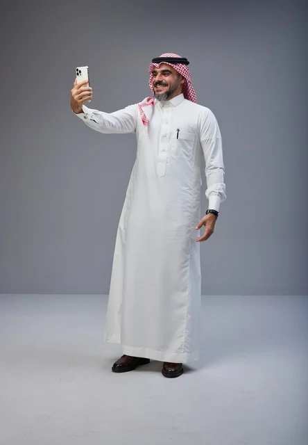 رجل سعودي بالزي التقليدي يلتقط صورة سيلفي