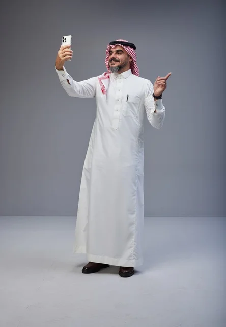 رجل سعودي بالزي التقليدي يلتقط سيلفي بالجوال