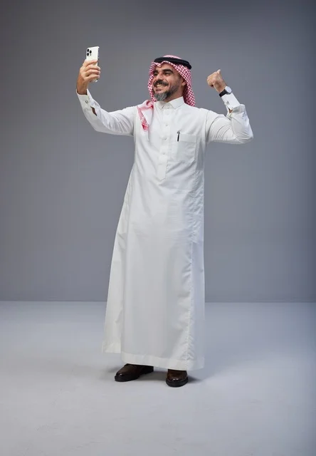 رجل سعودي بالزي التقليدي يلتقط سيلفي بالجوال