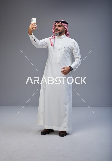 Saudi Man in Traditional Thobe Taking Selfie