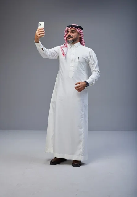 رجل سعودي بالزي التقليدي يلتقط صورة سيلفي