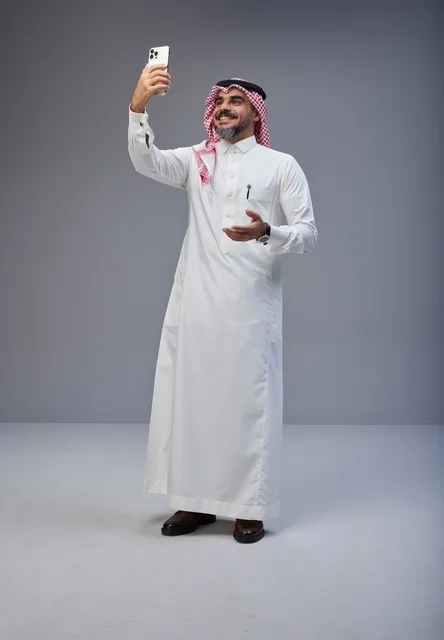 Saudi Man in Traditional Thobe Taking Selfie in Studio Saudi Man in Traditional Thobe Taking Selfie in Studio