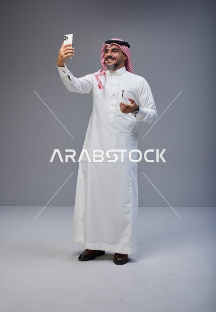 رجل سعودي بالزي التقليدي يلتقط صورة سيلفي