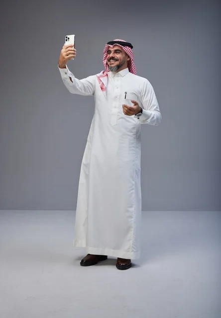 رجل سعودي بالزي التقليدي يلتقط صورة سيلفي