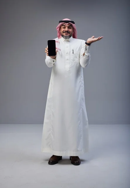 Saudi Man Holding Smartphone with Blank Screen in Studio Saudi Man Holding Smartphone with Blank Screen in Studio