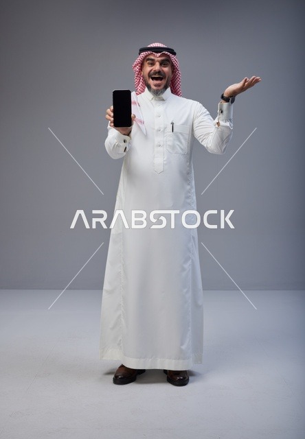 Saudi Man in Traditional Thobe Holding Smartphone