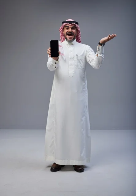 Saudi Man in Traditional Thobe Holding Smartphone