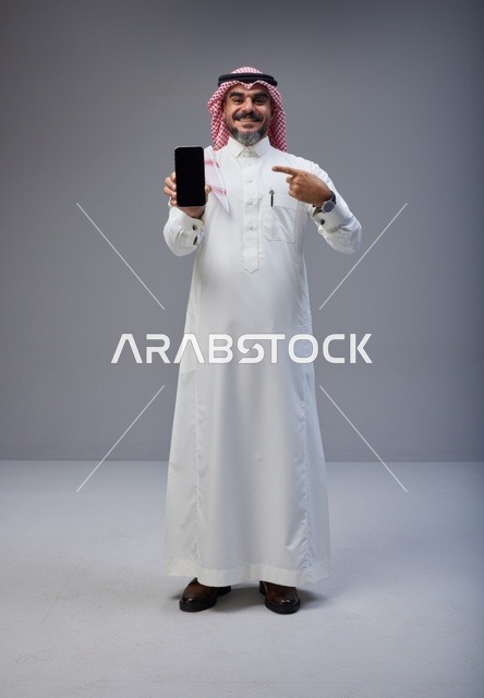 Saudi Man Holding Blank Smartphone Screen in Studio