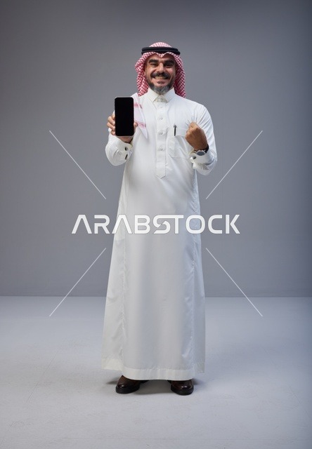 Saudi Man with Smartphone Success Gesture Studio