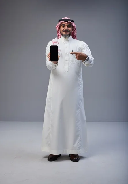 Saudi Man Pointing to Smartphone Screen in Studio Saudi Man Pointing to Smartphone Screen in Studio