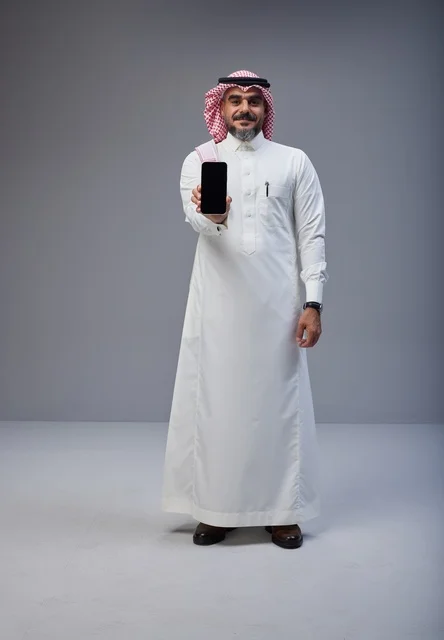 Saudi Man in Traditional Dress Holding Smartphone