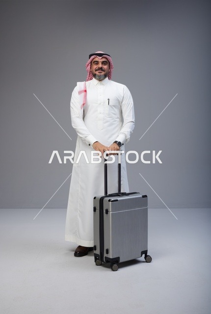Saudi Man in Traditional Attire with Travel Suitcase
