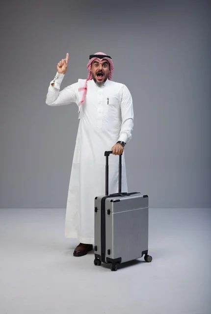 رجل سعودي بالزي التقليدي مع حقيبة سفر يشير للأعلى