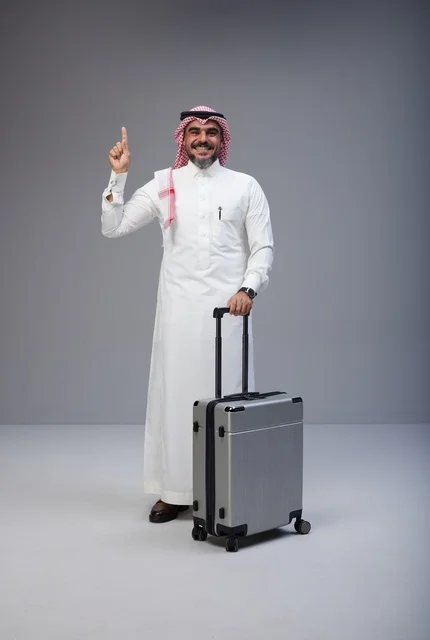 رجل سعودي بالزي التقليدي مع حقيبة سفر في الاستوديو