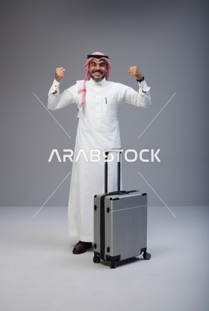 رجل سعودي مع حقيبة سفر يحتفل بنجاح الرحلة