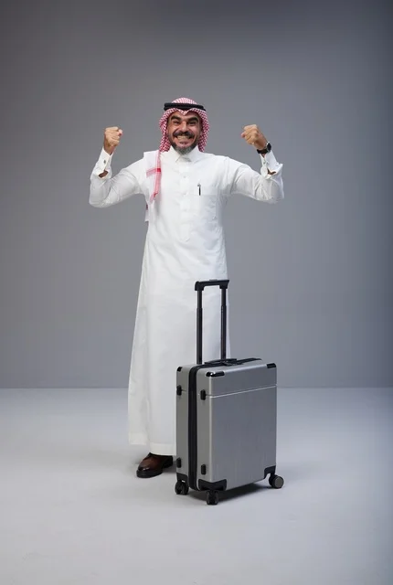 رجل سعودي مع حقيبة سفر يحتفل بنجاح الرحلة