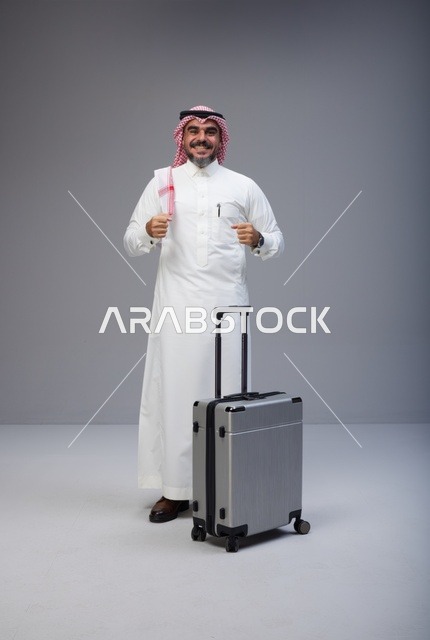 رجل سعودي بالزي التقليدي مع حقيبة سفر