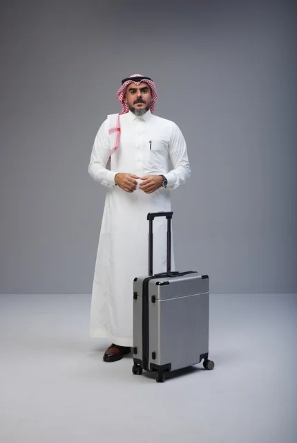 رجل سعودي بالزي التقليدي مع حقيبة سفر في الاستوديو