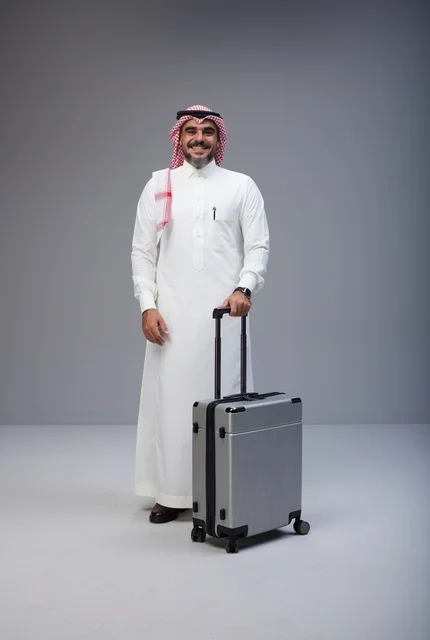رجل سعودي بالزي التقليدي مع حقيبة سفر في الاستوديو