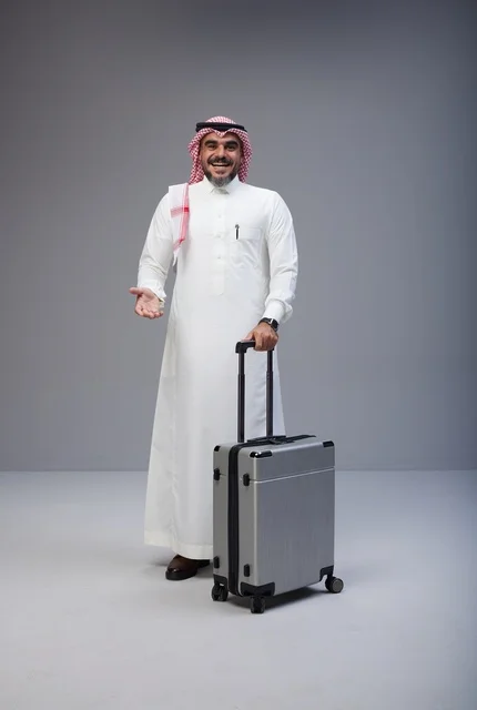 رجل سعودي بالزي التقليدي مع حقيبة سفر