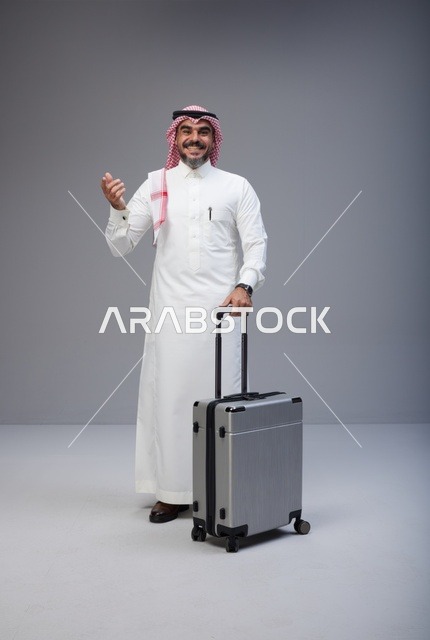 رجل سعودي بالزي التقليدي مع حقيبة سفر