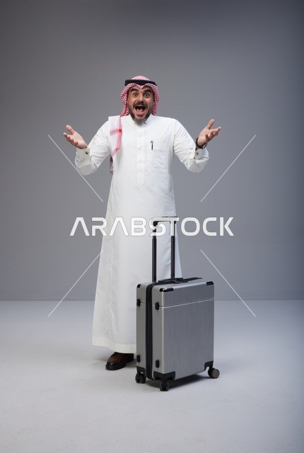 رجل سعودي يرتدي الزي التقليدي مع حقيبة سفر بتعبير متحمس