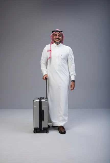 رجل سعودي بالزي التقليدي مع حقيبة سفر في الاستوديو