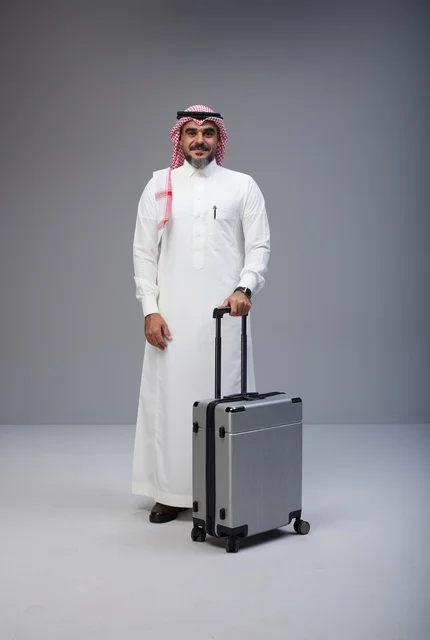 رجل سعودي بالزي التقليدي مع حقيبة سفر