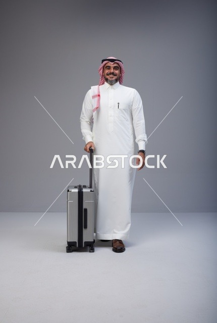 رجل سعودي بالزي التقليدي مع حقيبة سفر