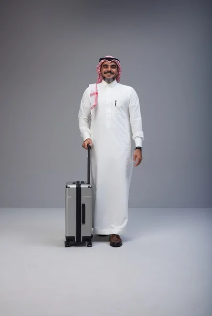 رجل سعودي بالزي التقليدي مع حقيبة سفر