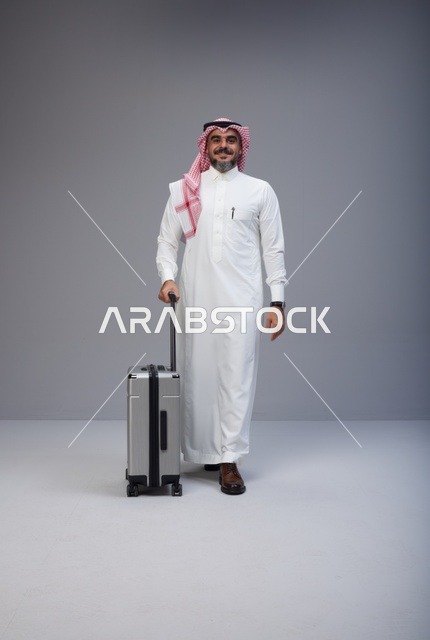 Saudi Man in Traditional Thobe Walking with Suitcase