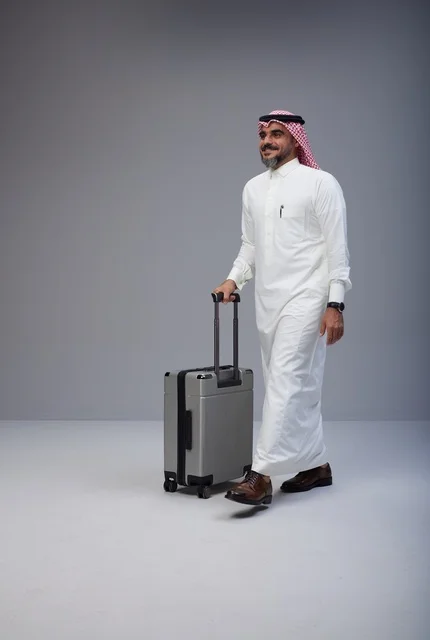 Saudi Man Walking with Travel Suitcase in Studio Saudi Man Walking with Travel Suitcase in Studio