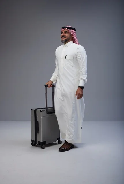 Saudi Man in Traditional Dress Walking with Suitcase