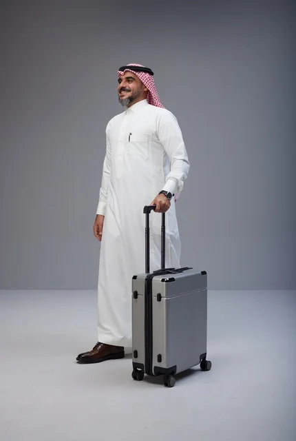 رجل سعودي بالزي التقليدي مع حقيبة سفر